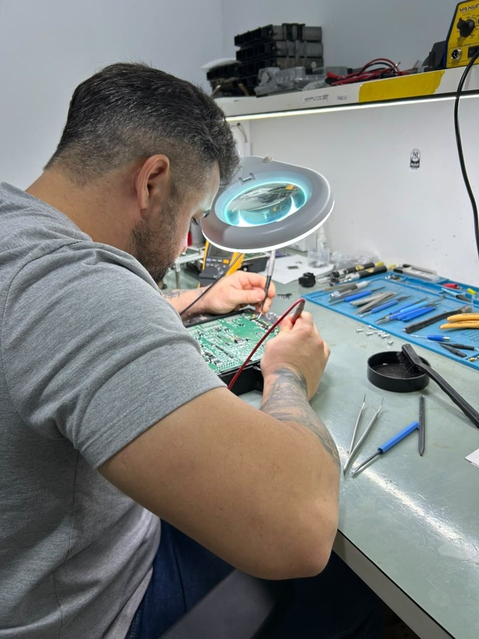 Técnico da Connect Máquinas reparando um monitor na bancada